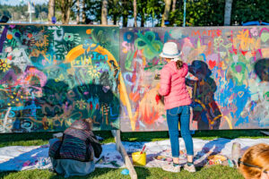Photos of children painting a makeshift wall in a park