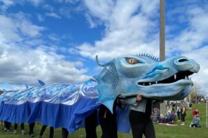 Photos of several people operating a large dragon costume in a park