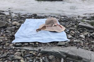 Photo of a beach towel and hat on a beach